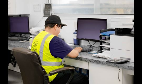 Dairy worker sitting at computer